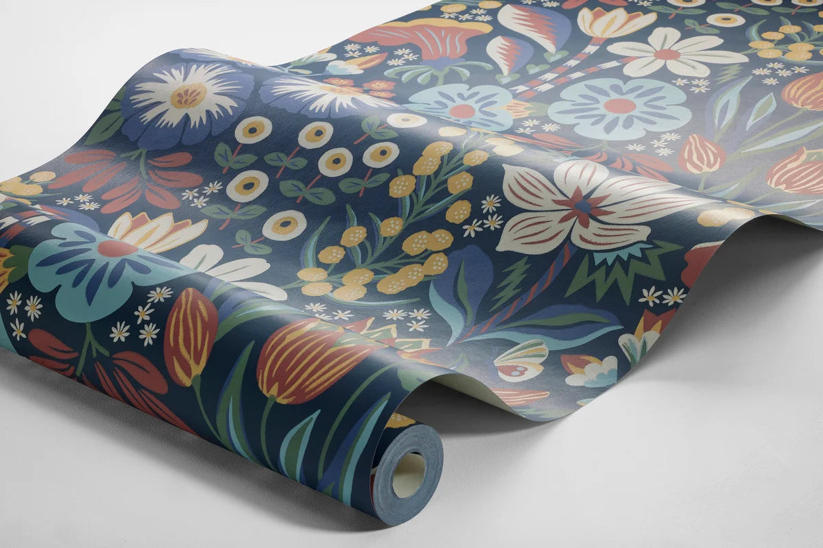 Colored in cheerful tones of green, turquoise, yellow, red and white on a deep dark blue background, our Trädgården wallpaper in a surface print brings a garden scene to life on your walls.