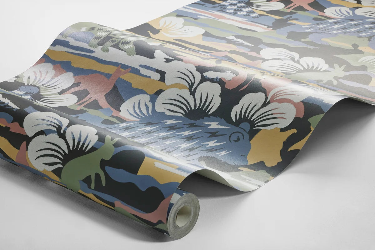 Set on a surface print, our Nomad wallpaper is colored in fun and playful tones of green, blue, red and white on a warm brown, black backdrop.