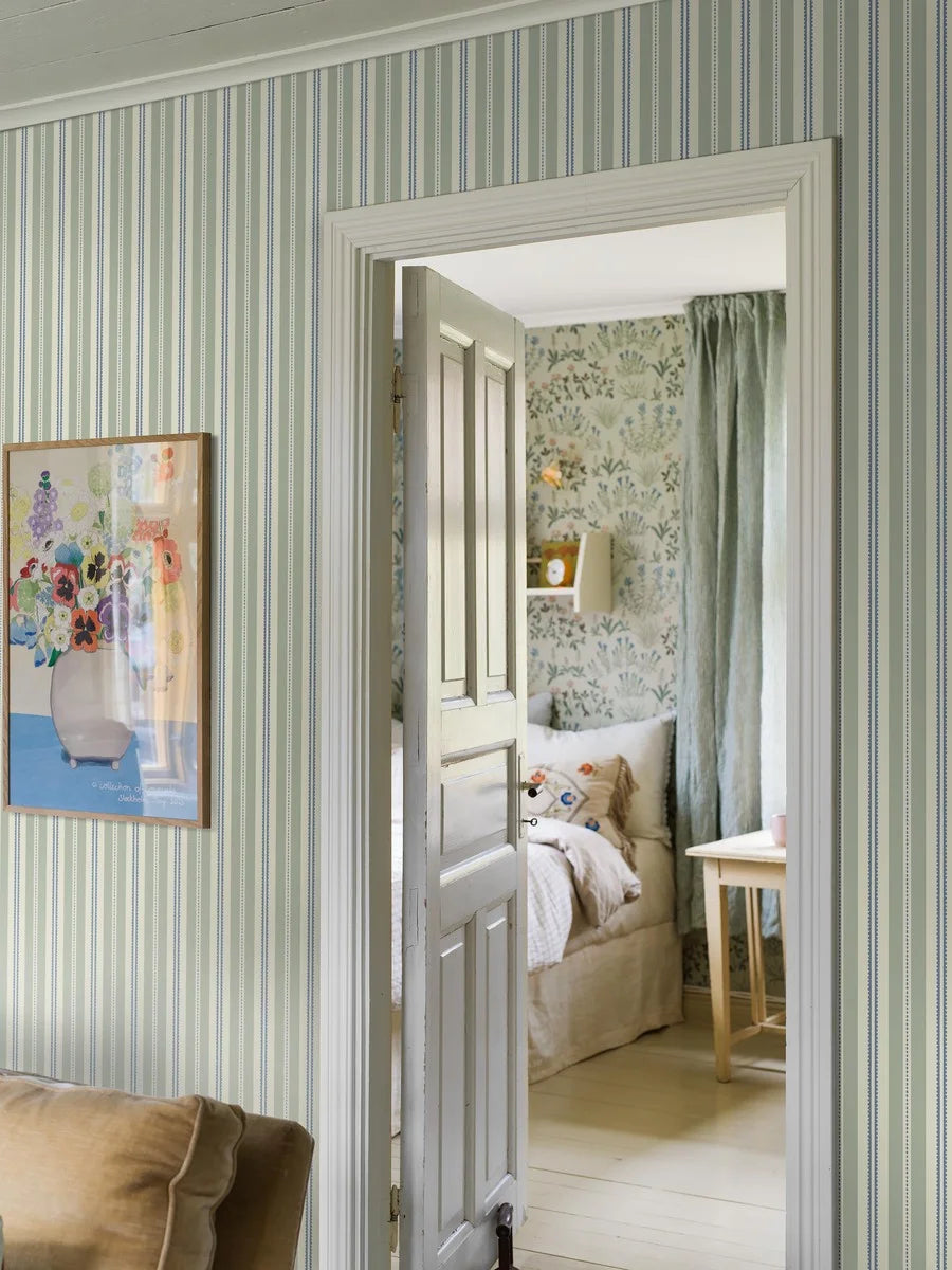Mild green stripes combine with warm, soft cobalt blue accents to give our Hedda wallpaper a serene and refreshing style.