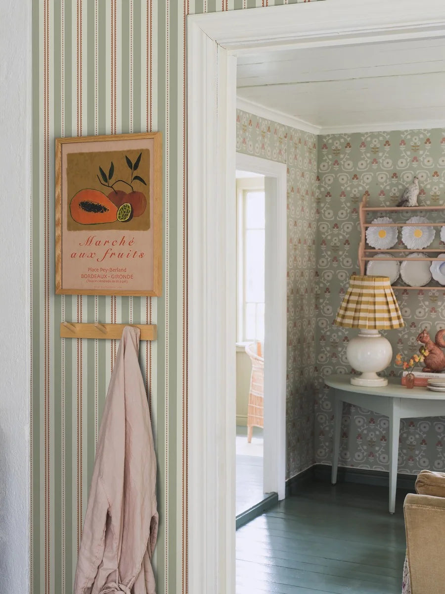 Colored in soft warm green stripes and striking rust-red accents, our Hedda wallpaper is contemporary yet classic in style.