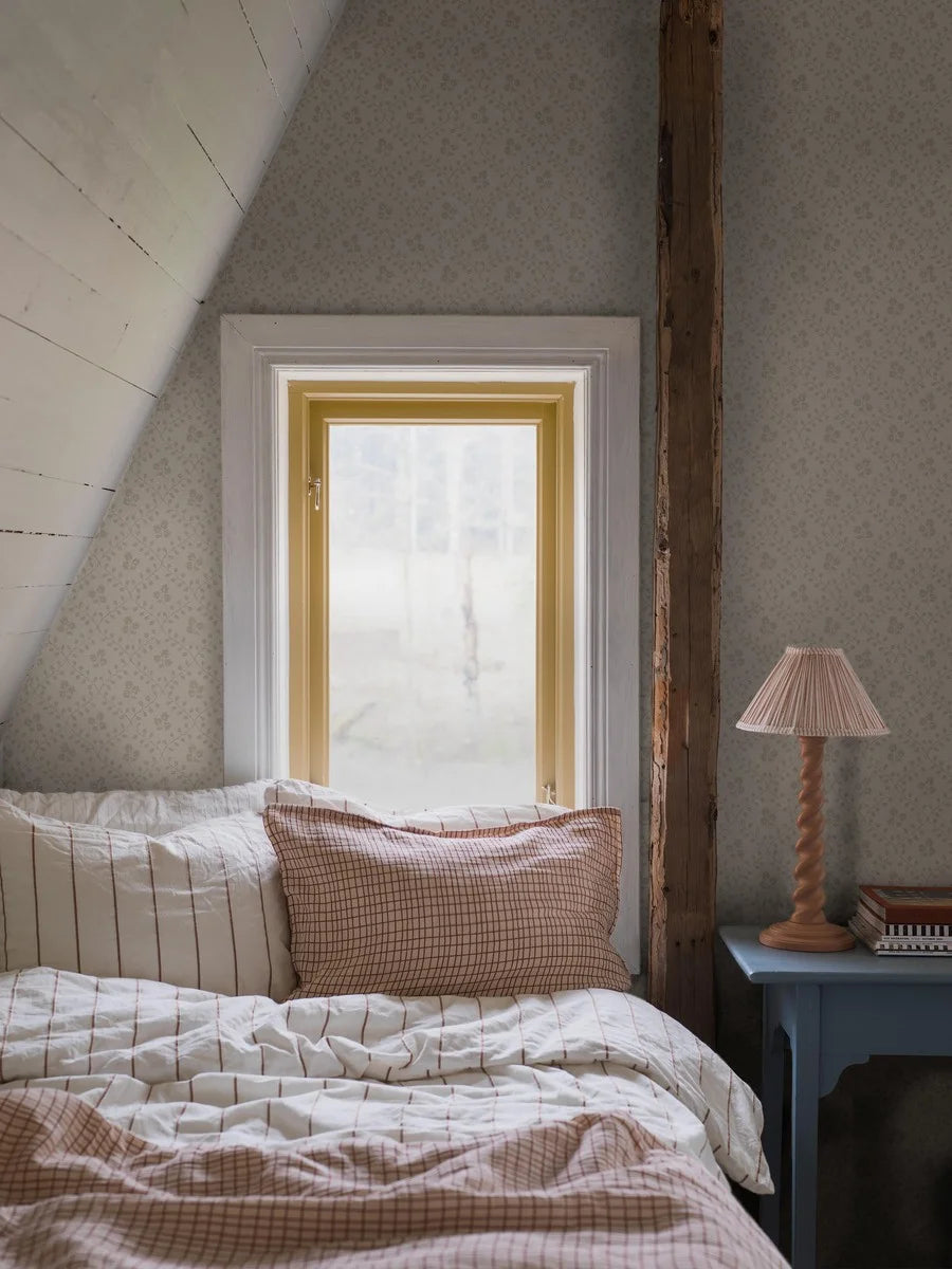 Subtle and sophisticated, our Idun wallpaper features a warm beige background with tone-on-tone beige flowers encased by a decorated yet dainty winding trellis.