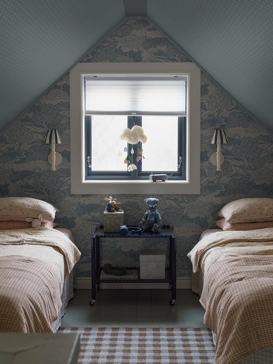 Colored in dove blue detailing on a linen grey background, our Solängen wallpaper offers a rich tapestry of natural beauty.