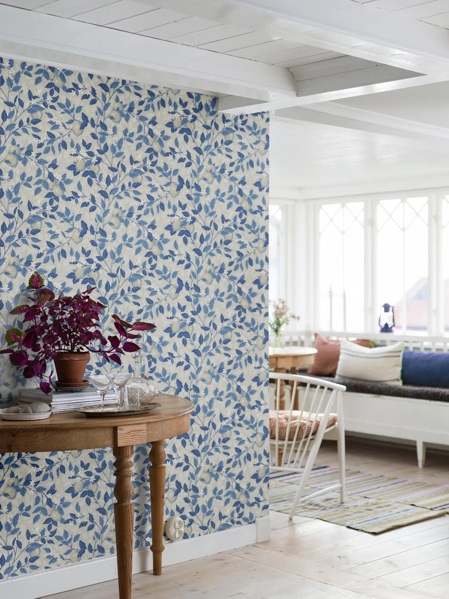 Printed using our traditional surface printing press, the Citronträd wallpaper features a gentle light beige base with classic blue tones adorning the leaves and stems of the lemon tree.