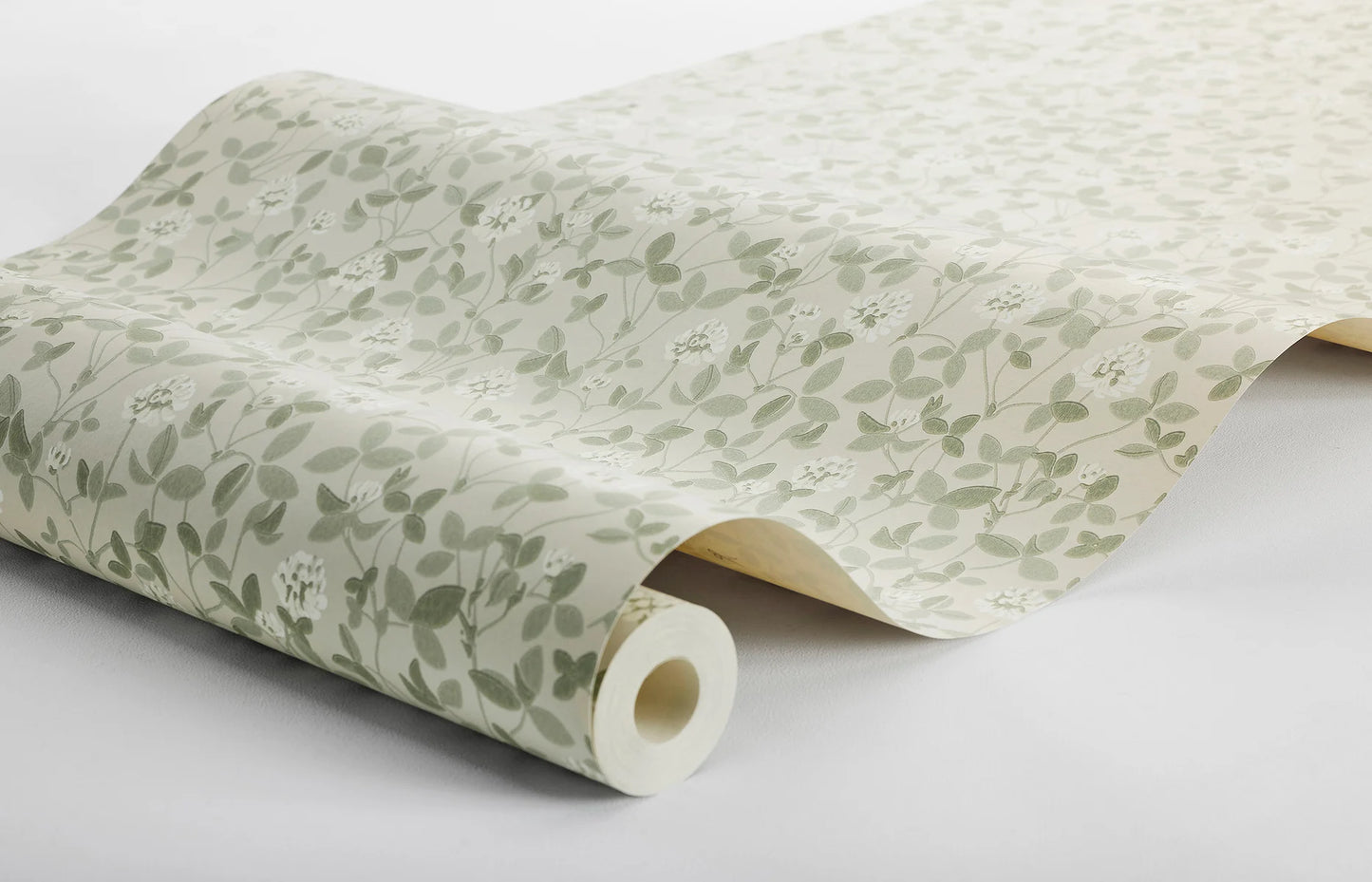 This beautiful Klöver wallpaper has warm white clover flowers among powdery olive-green leaves set on a light beige background.
