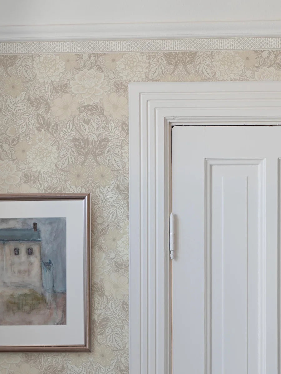 Featuring a dense yet subtle repeat geometric pattern, our Kalles Bård wallpaper border is colored in warm light beige tones and set on a fresh white background.