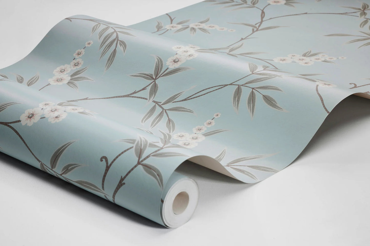 Our Floral Tree wallpaper pairs green leaves with soft white flowers on a serene sky-blue background, blending classic Chinoiserie motif inspiration with a modern aesthetic.