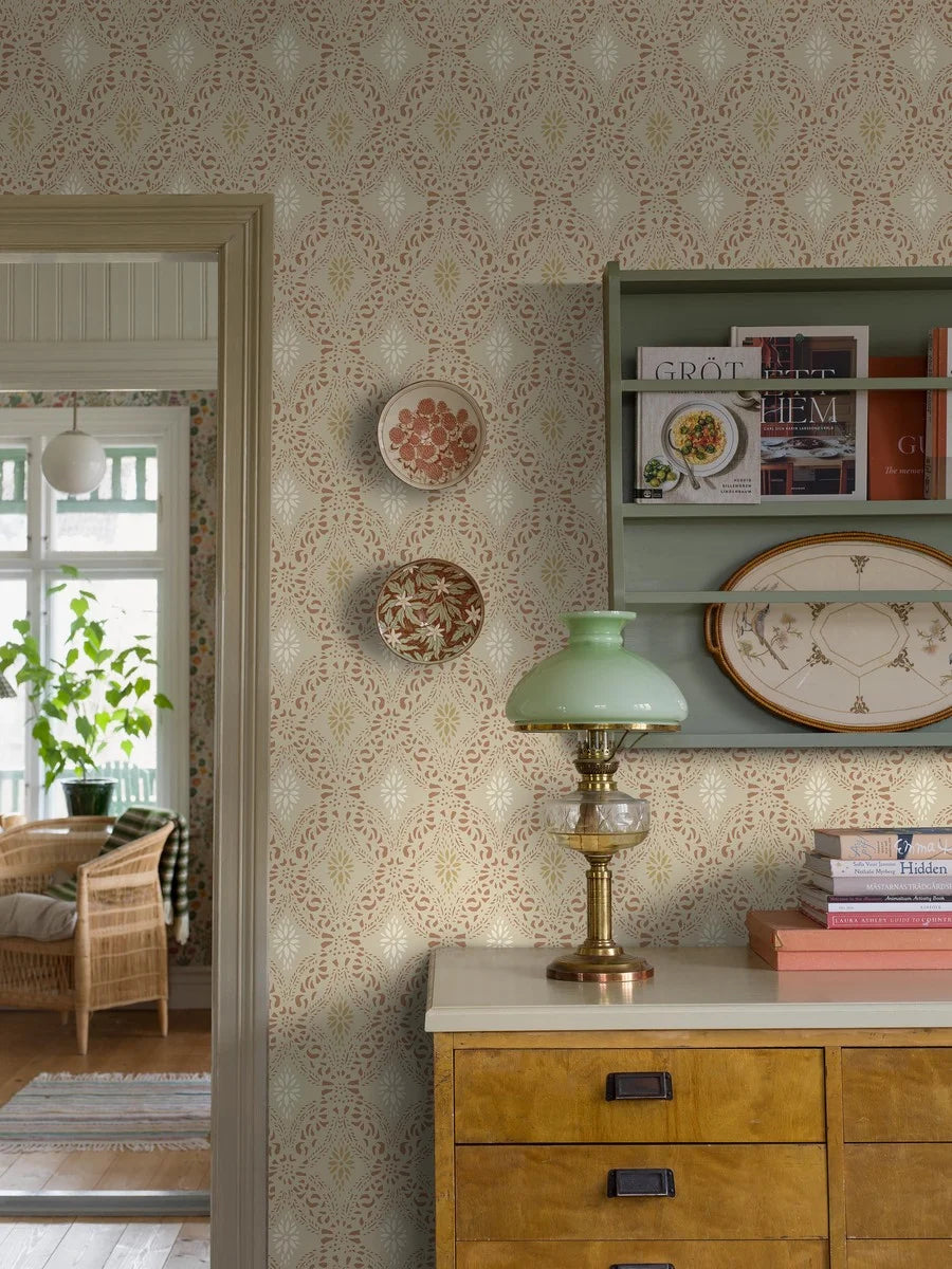 Featuring a timeless stencil pattern, our Kvarnholmen wallpaper comes alive in earthy tones of terracotta, ochre and soft white, gently layered over a warm beige background.