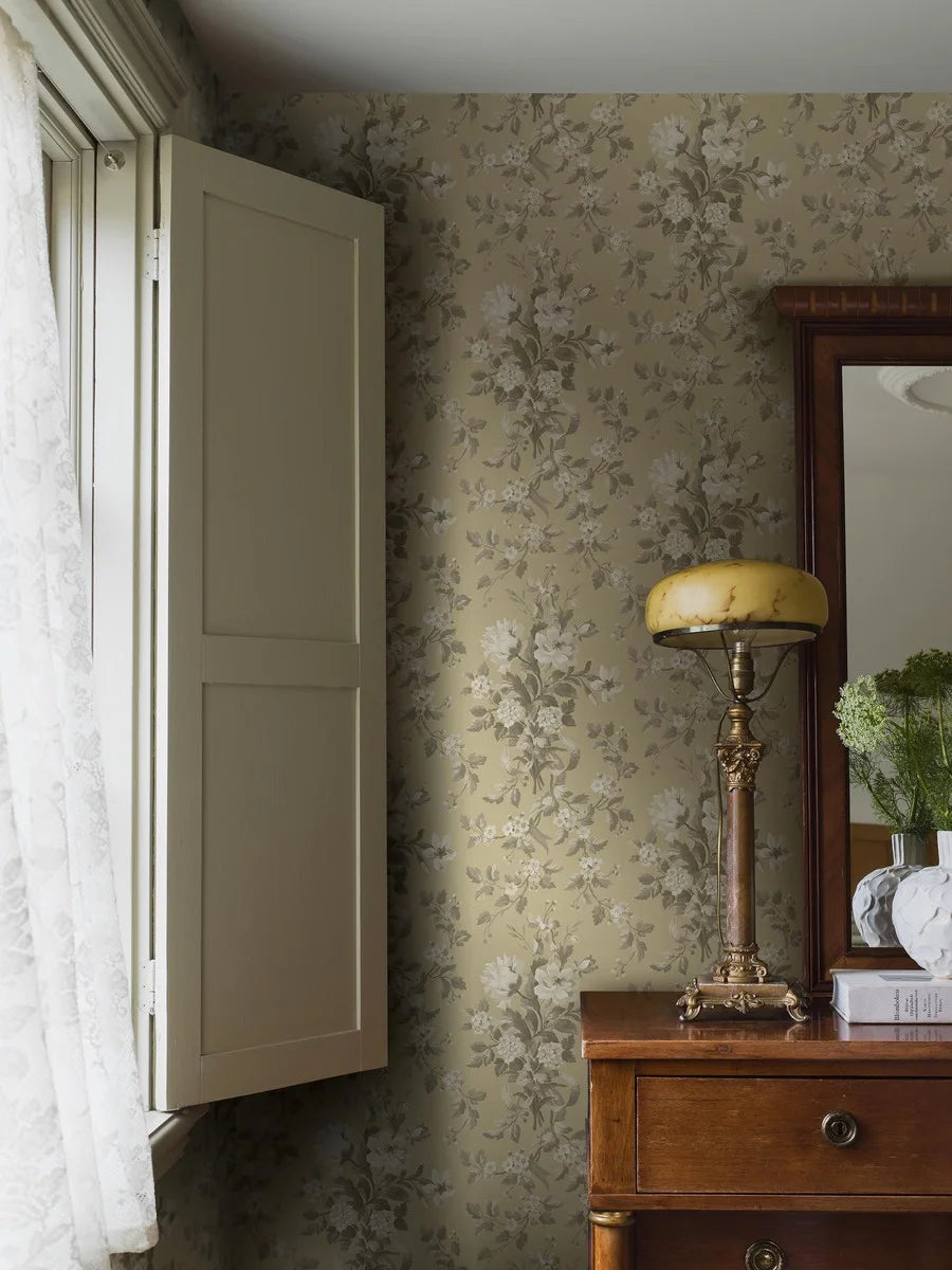 Colored in a muted yellow with beige and grey-brown detailing, our Tullgarn wallpaper brings graceful and royal elegance to your space.