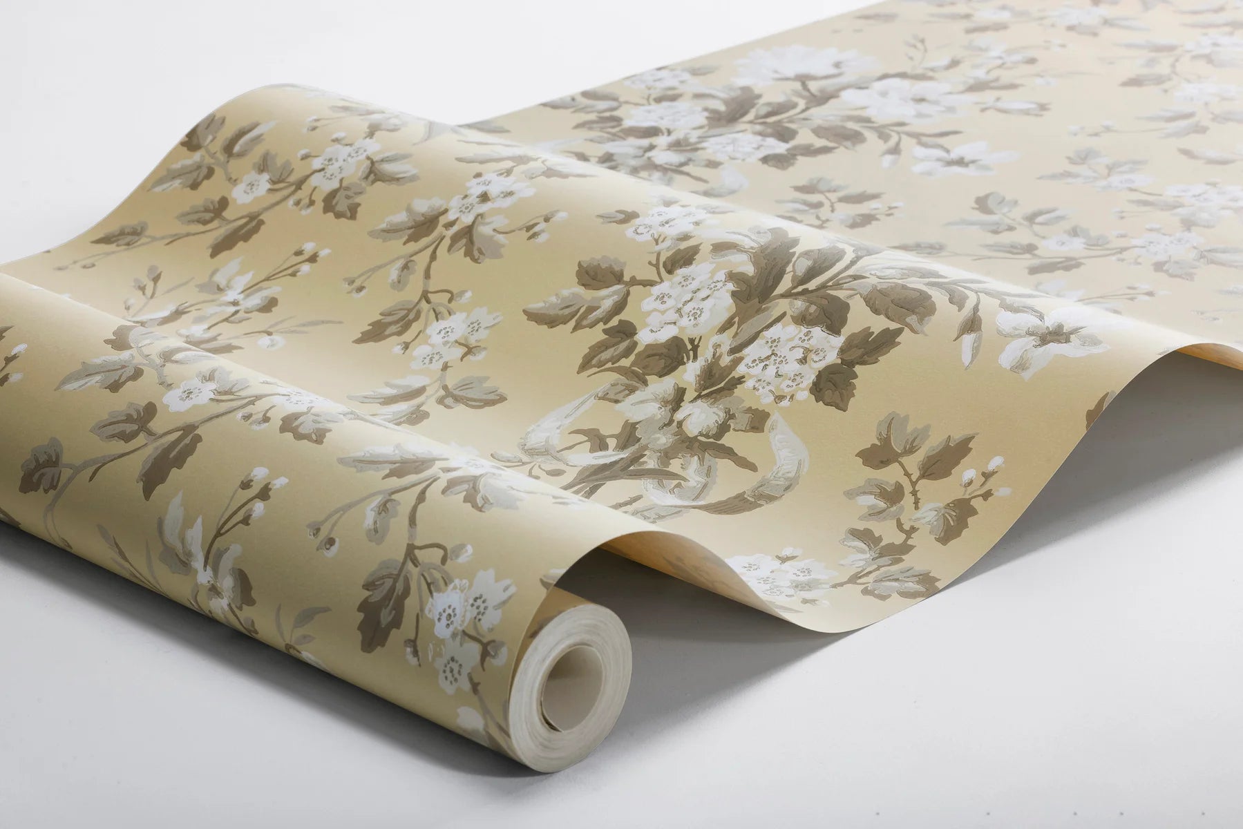 Colored in a muted yellow with beige and grey-brown detailing, our Tullgarn wallpaper brings graceful and royal elegance to your space.