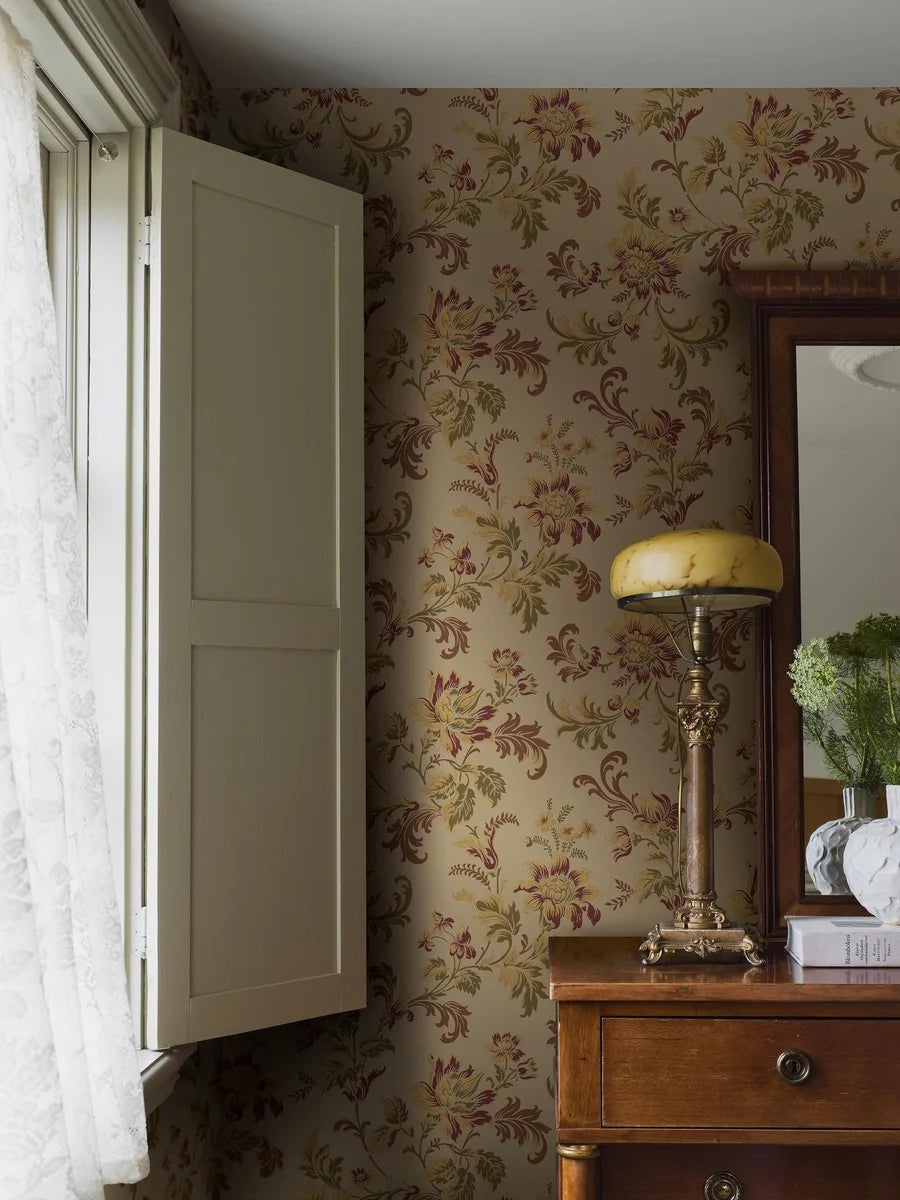 Evocative and autumnal, our Elvira wallpaper is colored in its original 1900s palette – olive, maroon and purple tones on a warm beige background.