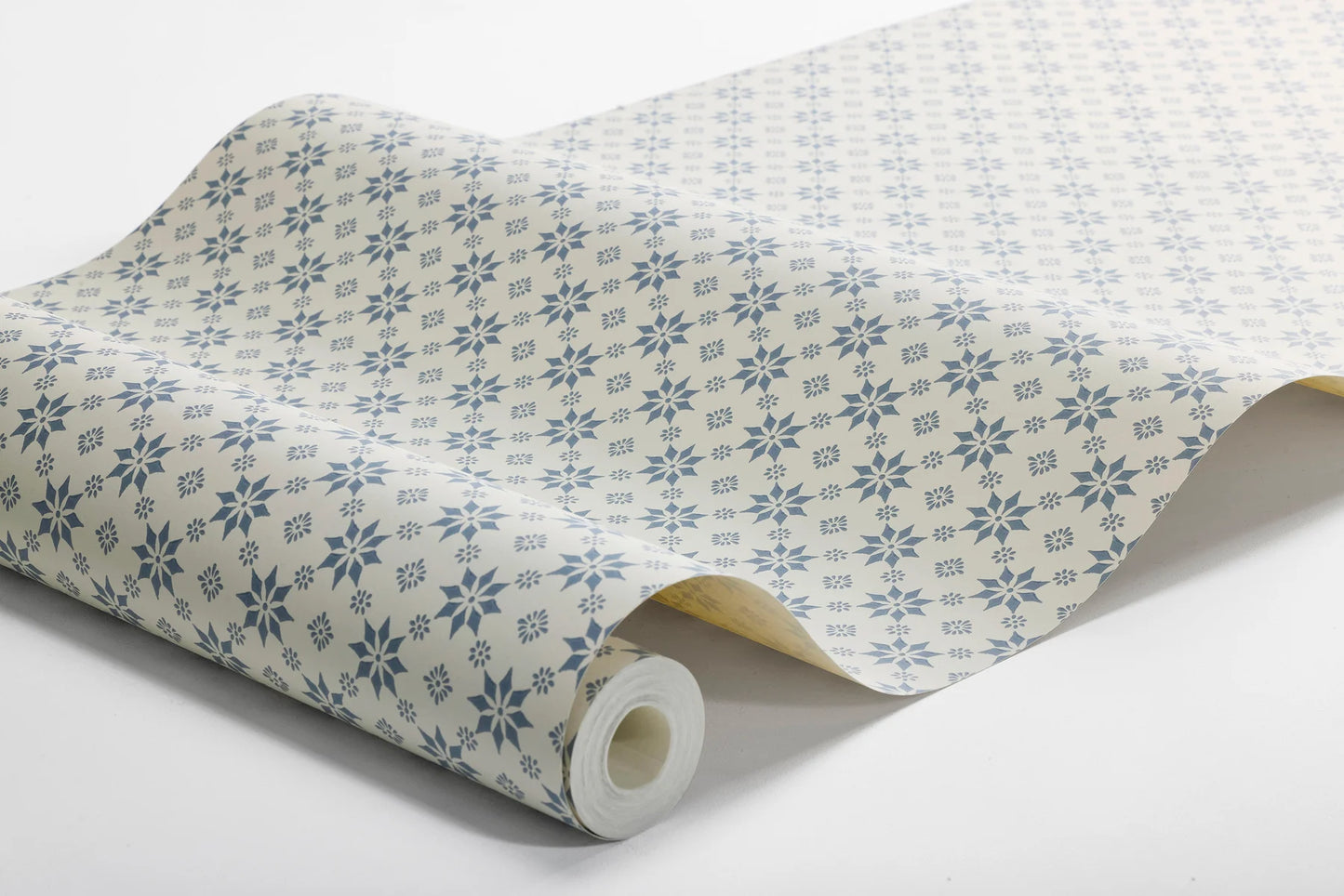 Set on a natural background with muted blue detailing, our Stella wallpaper balances structure and whimsy perfectly.
