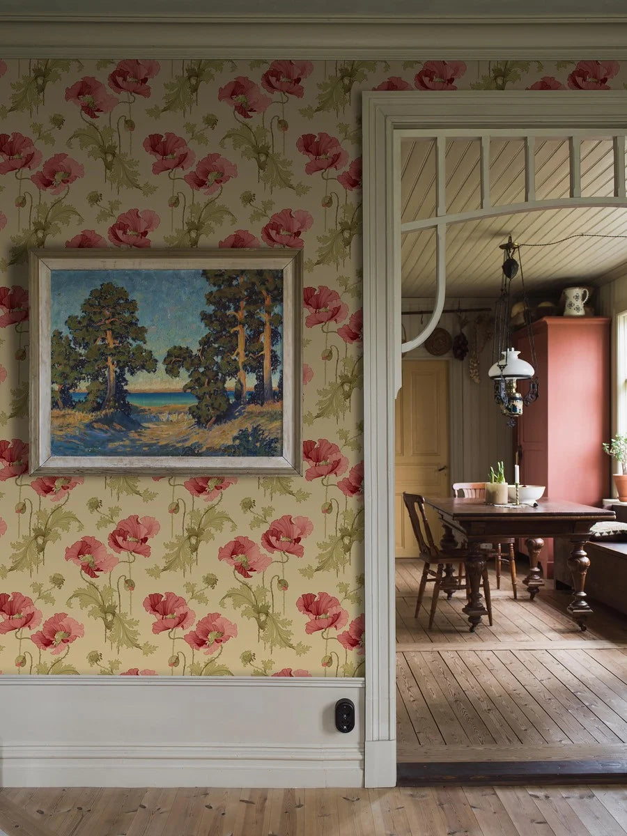 This Vallmo wallpaper features classic red poppies and green leaves on a soft beige background with ochre tones.