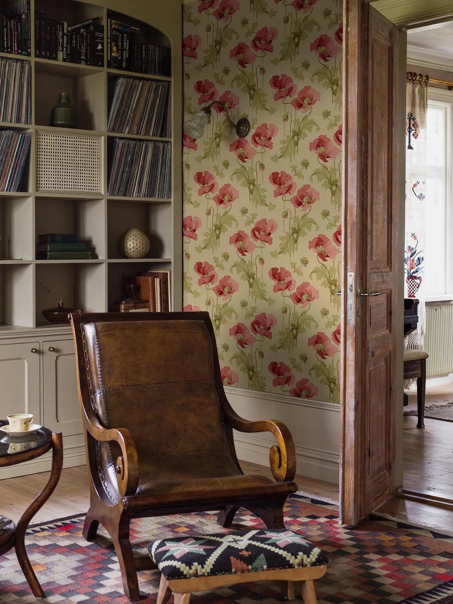 This Vallmo wallpaper features classic red poppies and green leaves on a soft beige background with ochre tones.