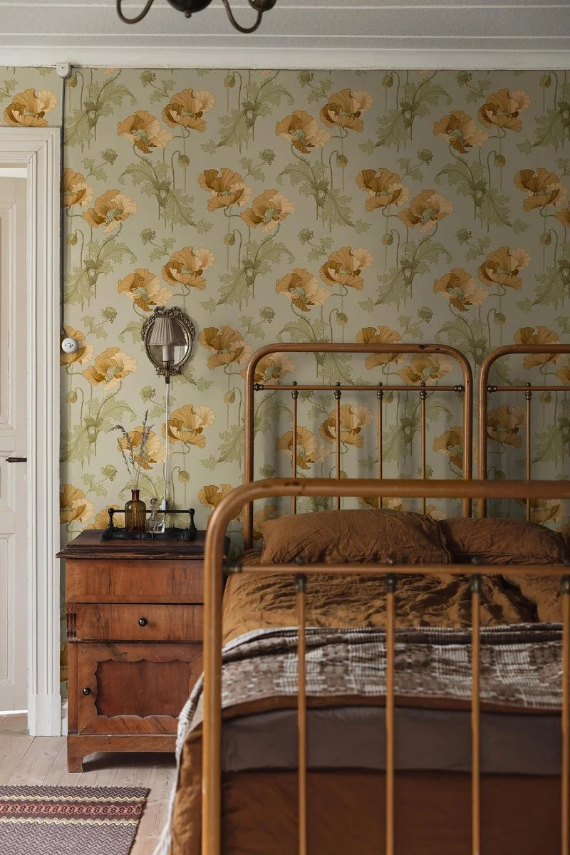 The stately poppies in this Vallmo wallpaper are colored in golden ochre and sandy yellow blooms on a soft green background