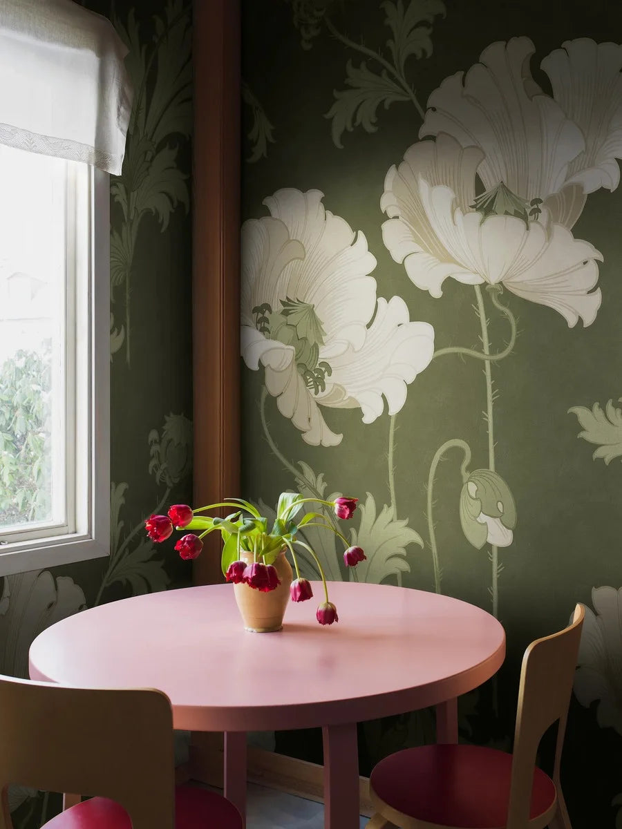 This Vallmo mural wallpaper is adorned with large, warm white flowers with fresh green leaves, buds and seed pods on a deep dark green background.