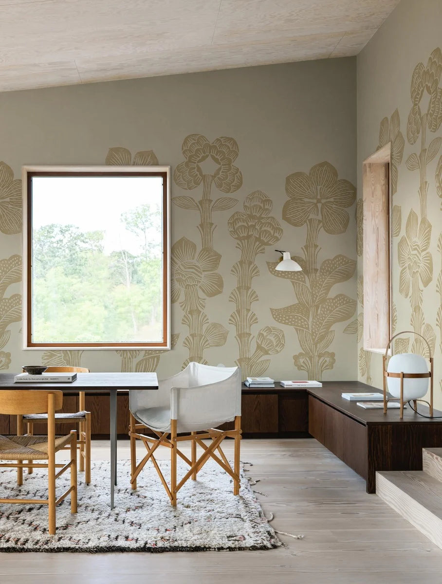 Storflax is a bright, playful mural wallpaper featuring a graphic pattern of pale yellow fantasy flowers stretching from the floor to the ceiling over a lightly textured, warm beige base.