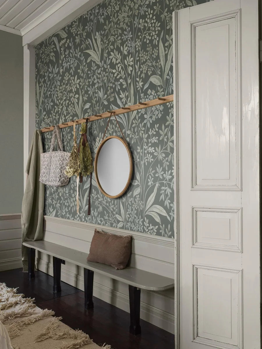 Nocturne Grand is a mural wallpaper featuring winding leaves, small flowers, and seed pods – a large-scale pattern softened by the chalk-like surface of the background.