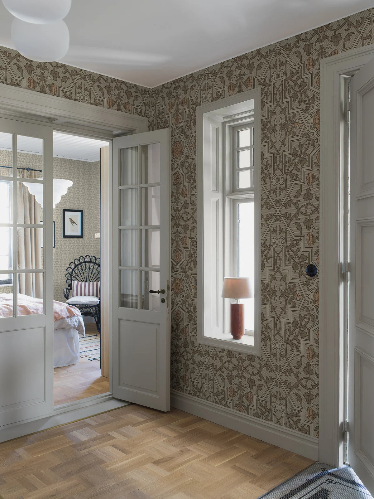 Rosenvinge Grand Wallpaper mural here unfolds in a soft, natural color scheme with details in green and apricot on a light grey-green background.