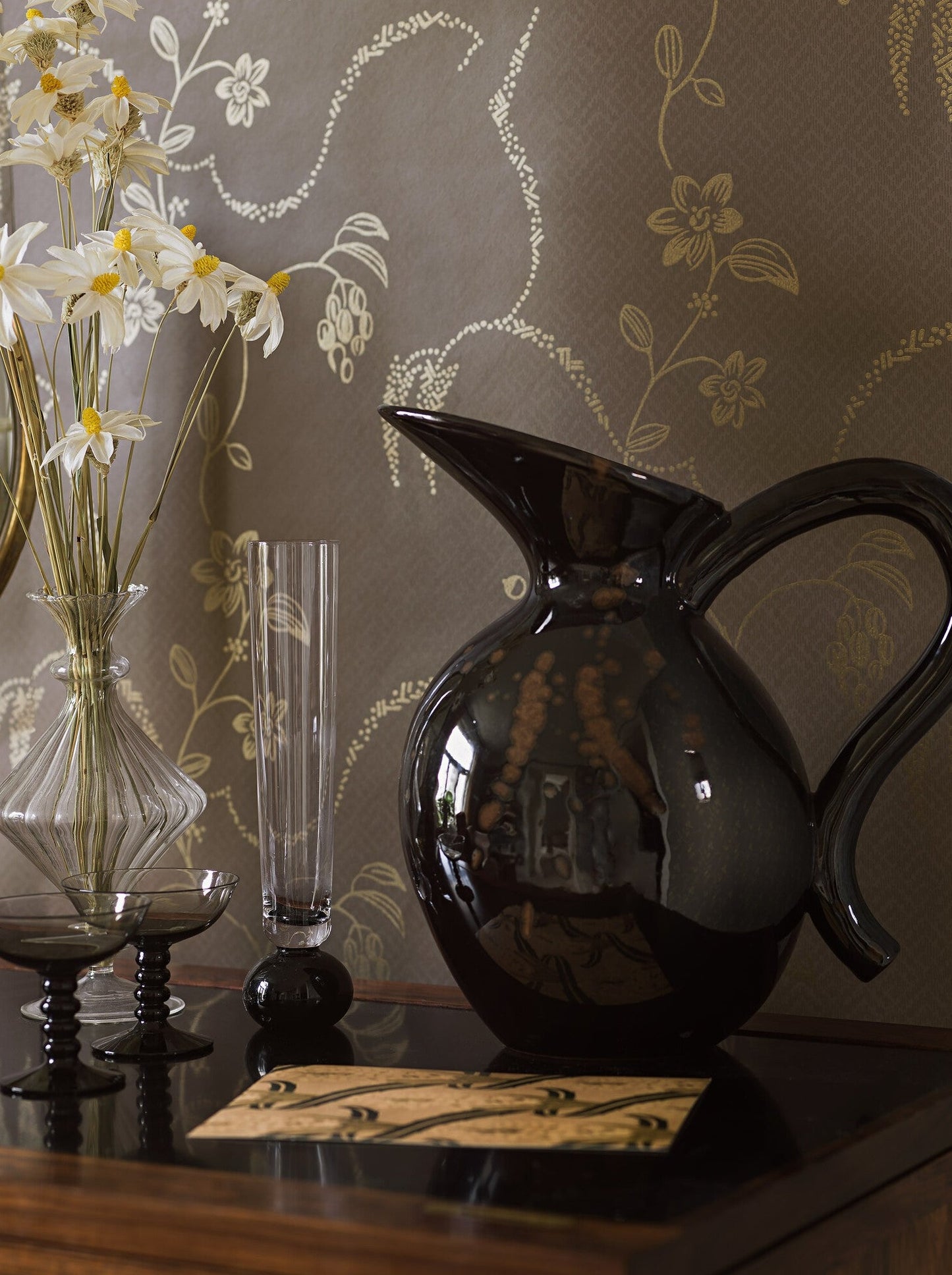 With its rich dark brown background offsetting a luxurious floral pattern in shimmering gold, our Elsie wallpaper has a cosy yet luxurious charm.