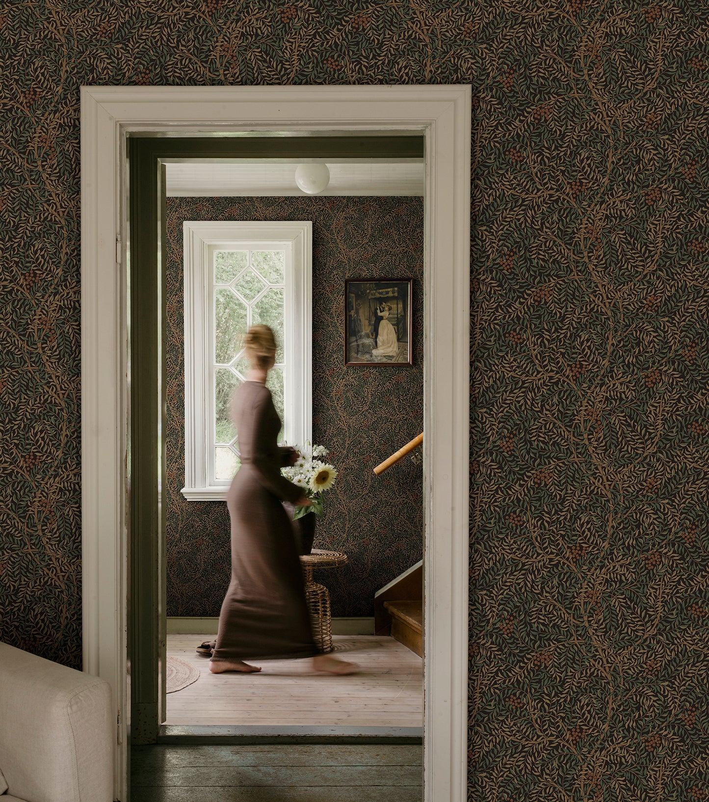 A harmonious surface-printed wallpaper pattern featuring intricate rowan berry branches creates a cozy and welcoming atmosphere with its stylized and enveloping design.