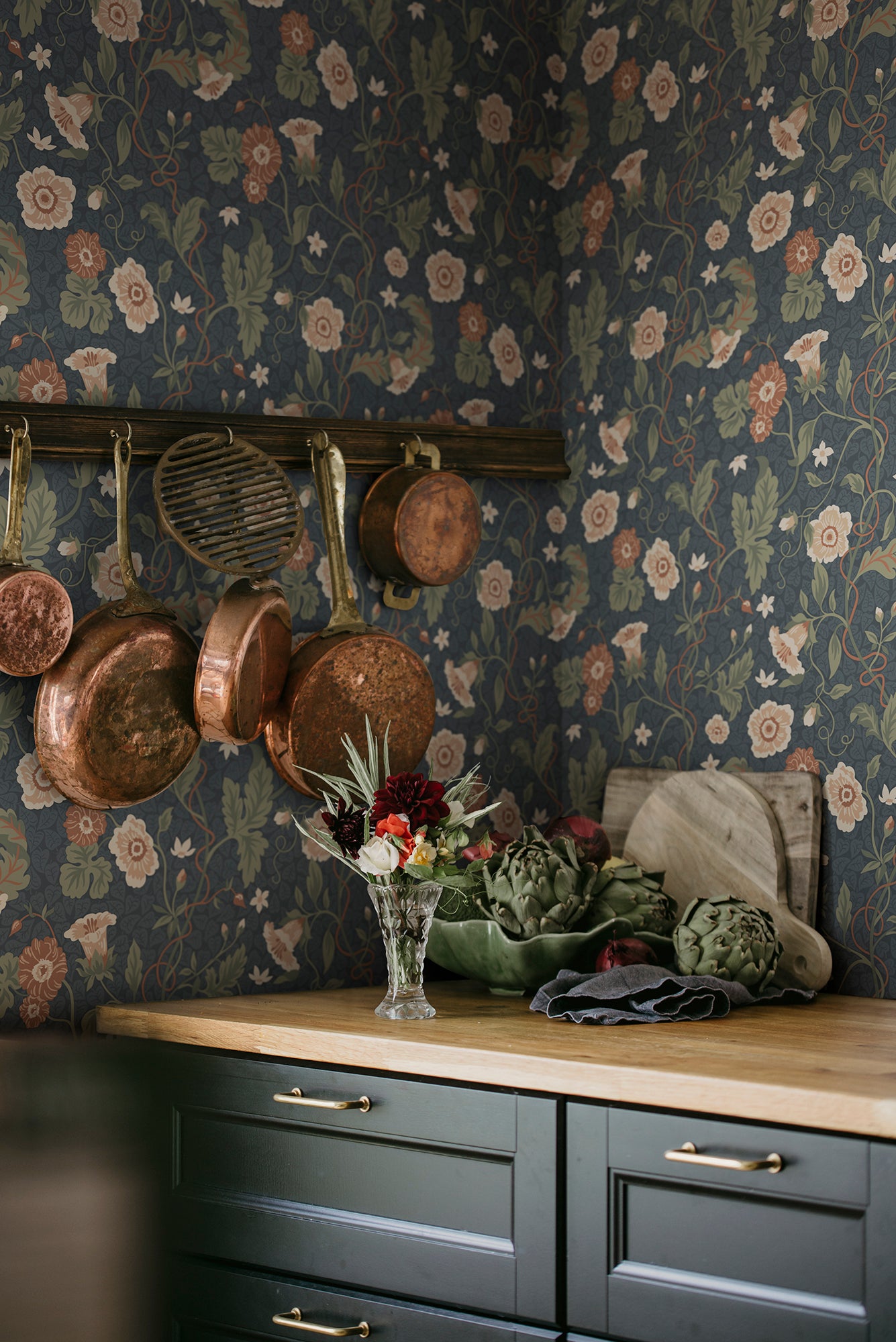 Japanese anemones, cup-and-saucer vines, and avens intertwined offer a softly verdant Arts & Crafts-inspired wallpaper with intricate details and an enveloping character.