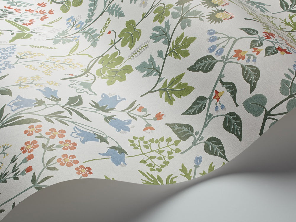 Colored in a bright and playful palette of green, red, yellow, white and blue on a fresh white backdrop, our Flora wallpaper brings the delights of spring to your home all year round.