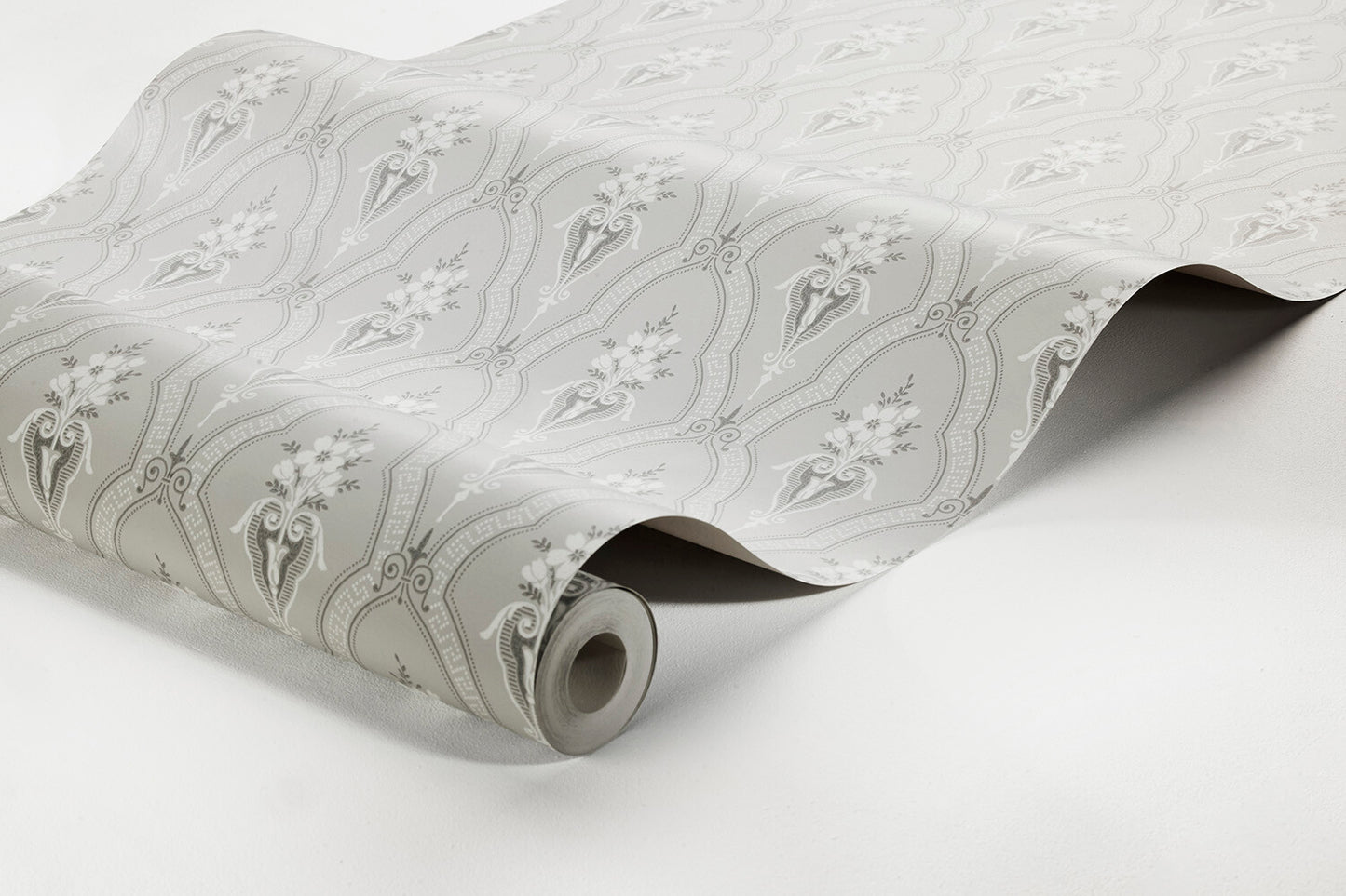 In soft misty shades of light grey with white detailing, our Klädesholmen wallpaper features a timeless and fresh design from the late 19th century.