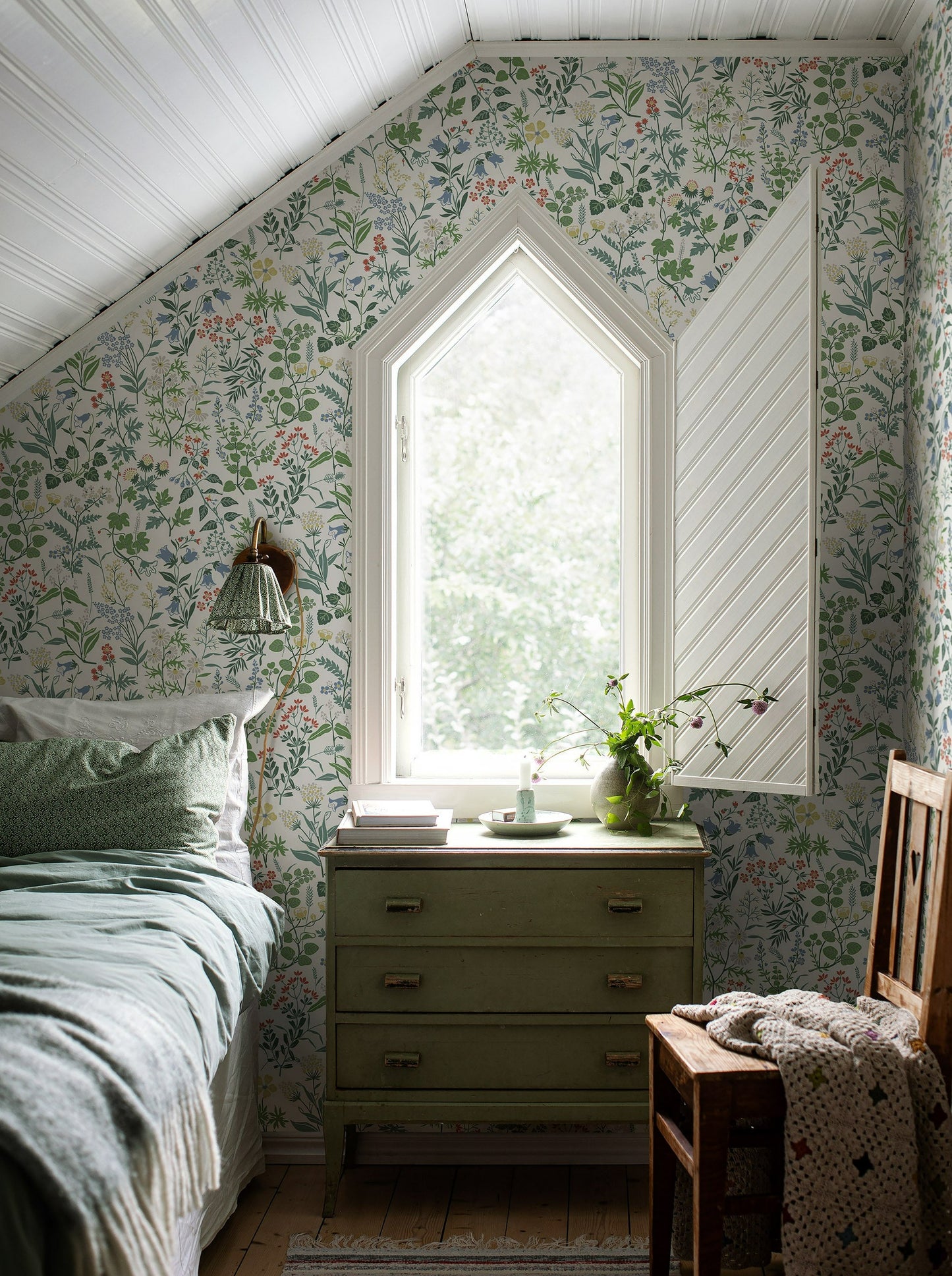 Colored in a bright and playful palette of green, red, yellow, white and blue on a fresh white backdrop, our Flora wallpaper brings the delights of spring to your home all year round.