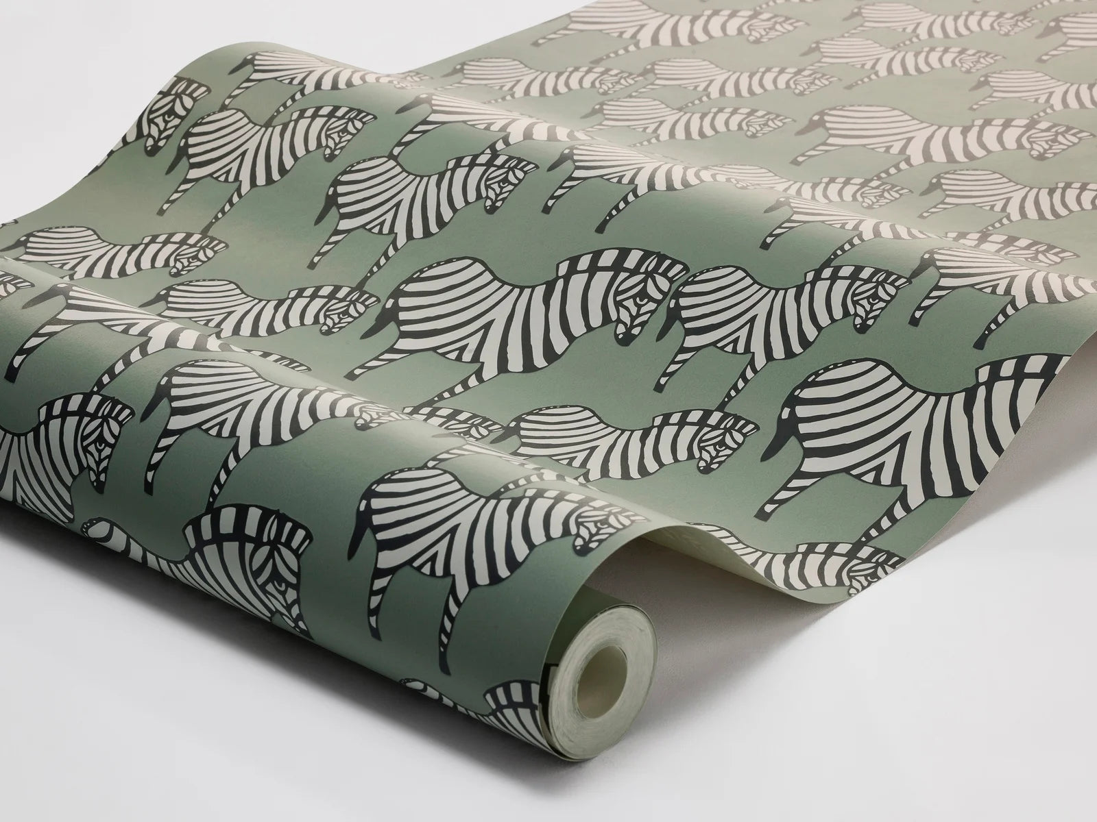 A herd of black and white zebras move gracefully across a gentle green backdrop in our Zebra wallpaper. Inspired by Lisa Larson’s much-loved ceramic zebra, originally created in 1957, this version of our wallpaper has a milder palette that preserves the design’s lively rhythm and charm.