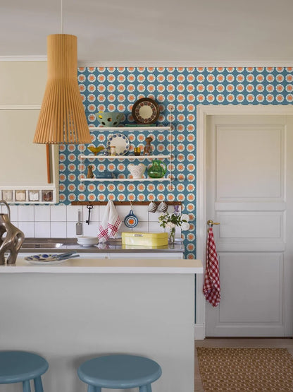 Bursting with the bold florals and carefree spirit of the late 1960s, our Daisy wallpaper brings joy at every glance. Seen here in its original retro blue and orange colorway, Turi Gramstad Oliver’s stylised daisies dance across the wall with playful energy.
