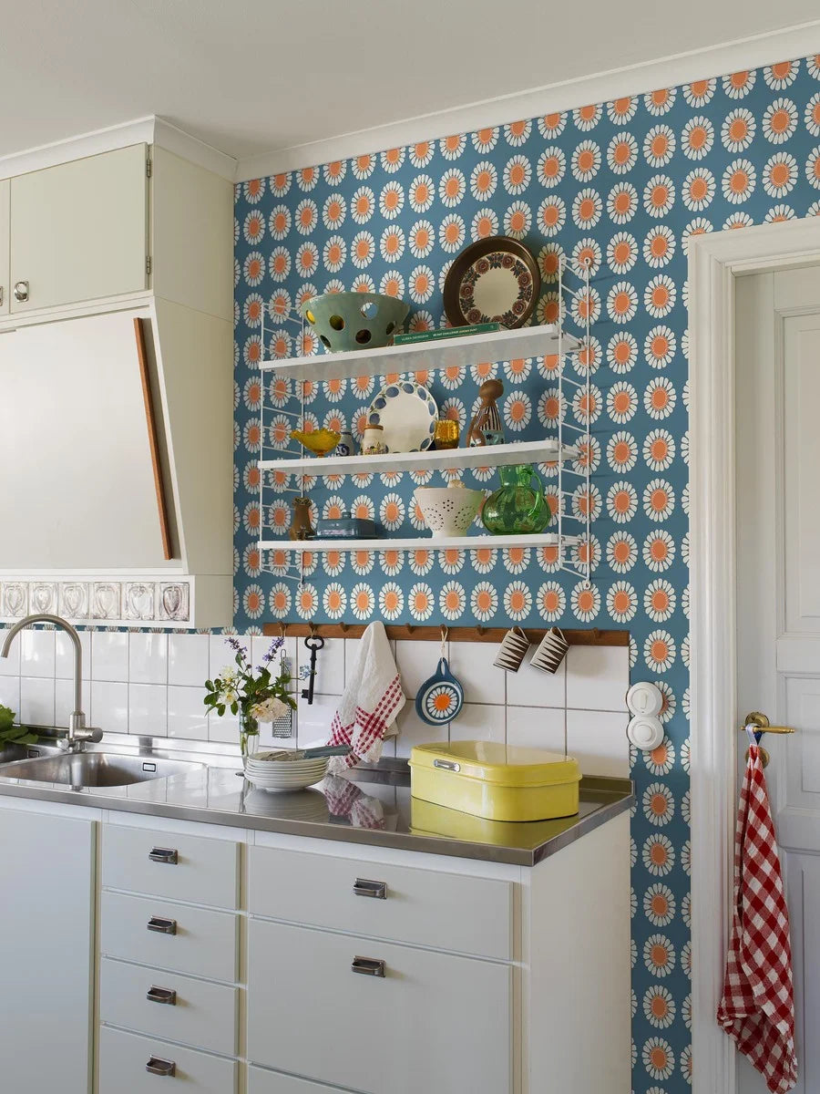 Bursting with the bold florals and carefree spirit of the late 1960s, our Daisy wallpaper brings joy at every glance. Seen here in its original retro blue and orange colorway, Turi Gramstad Oliver’s stylised daisies dance across the wall with playful energy.