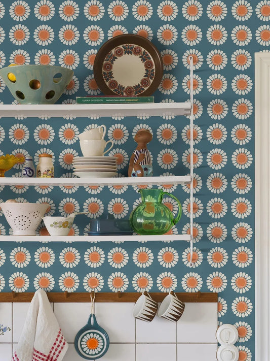 Bursting with the bold florals and carefree spirit of the late 1960s, our Daisy wallpaper brings joy at every glance. Seen here in its original retro blue and orange colorway, Turi Gramstad Oliver’s stylised daisies dance across the wall with playful energy.