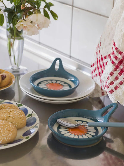 Bursting with the bold florals and carefree spirit of the late 1960s, our Daisy wallpaper brings joy at every glance. Seen here in its original retro blue and orange colorway, Turi Gramstad Oliver’s stylised daisies dance across the wall with playful energy.