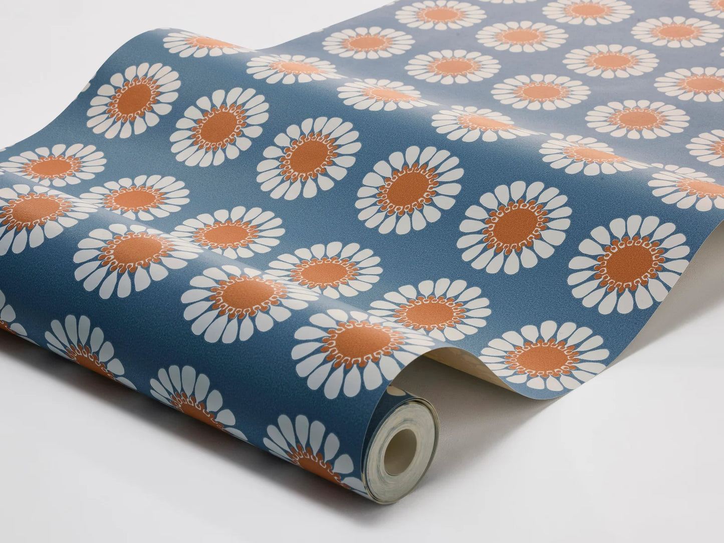 Bursting with the bold florals and carefree spirit of the late 1960s, our Daisy wallpaper brings joy at every glance. Seen here in its original retro blue and orange colorway, Turi Gramstad Oliver’s stylised daisies dance across the wall with playful energy.