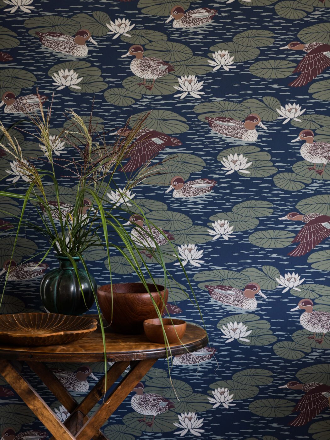 Wallpaper with beautifully patterned ducks camouflage with the water lily pads in a luscious design that gives any room a snug yet cool atmosphere.