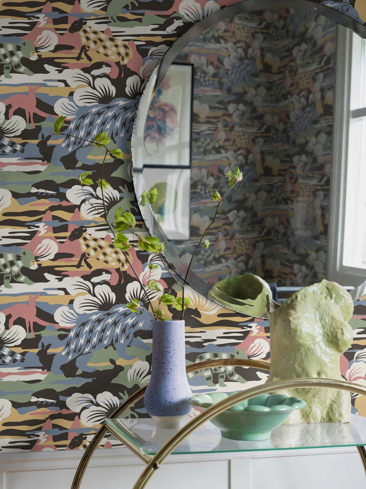 Set on a surface print, our Nomad wallpaper is colored in fun and playful tones of green, blue, red and white on a warm brown, black backdrop. 
