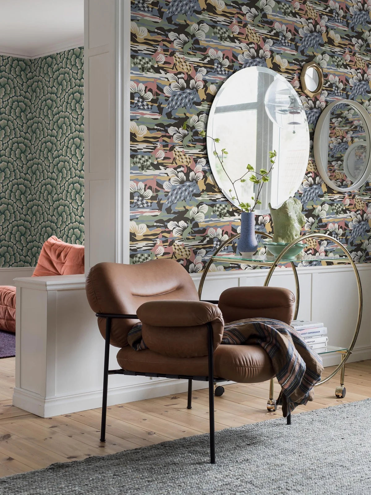 Set on a surface print, our Nomad wallpaper is colored in fun and playful tones of green, blue, red and white on a warm brown, black backdrop. 