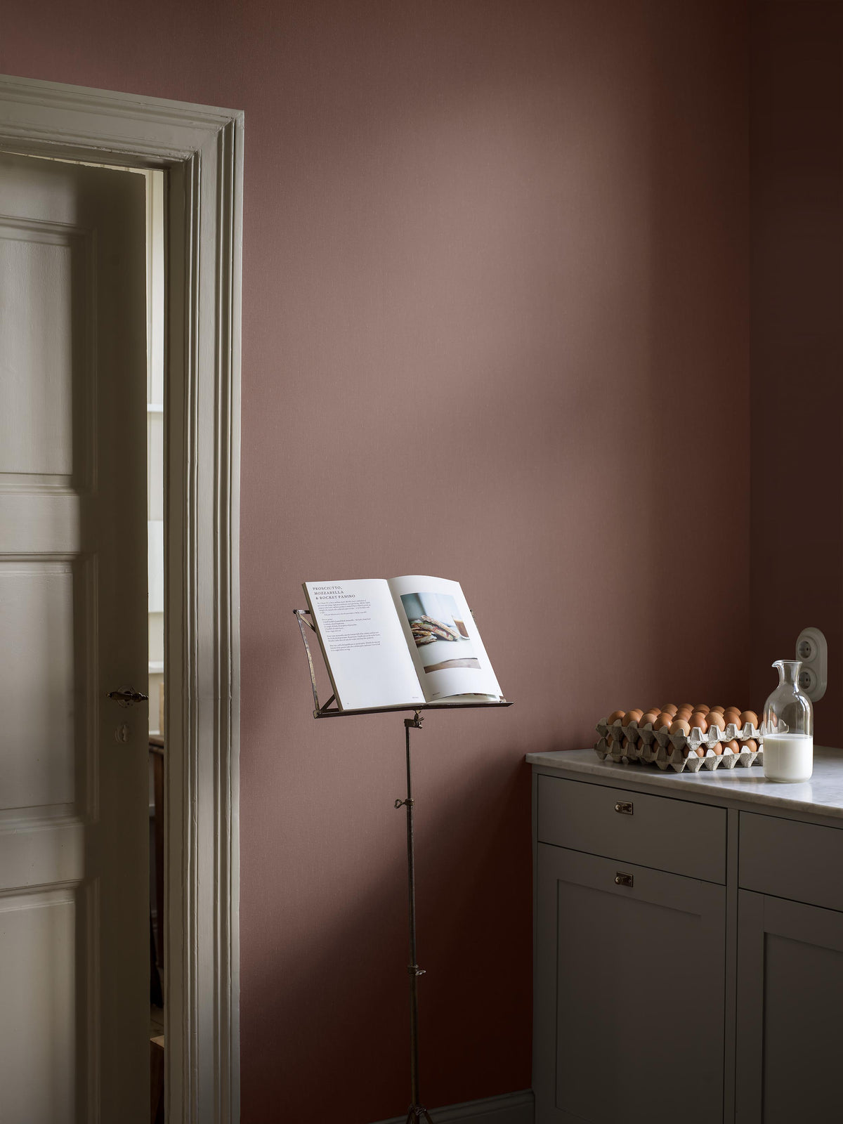 Marsala Linen comes in a medium-dark, muted wine-red shade with a soft Blue undertone that gives the color balance and depth. The subtle linen texture lends the surface a lively expression and a gentle shimmer as the light falls across the wall.