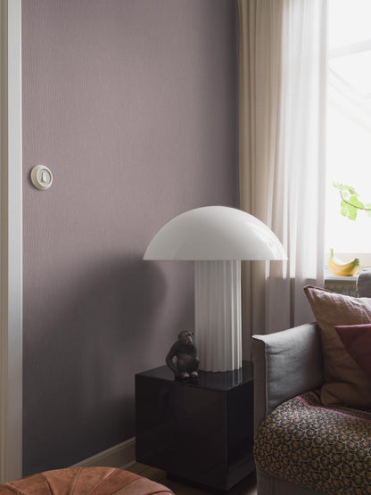 Lilac Linen is a softly muted Purple wallpaper with a warm undertone that evokes blooming lilacs. The subtle linen texture gives the surface a lively expression and a soft, textile feel.