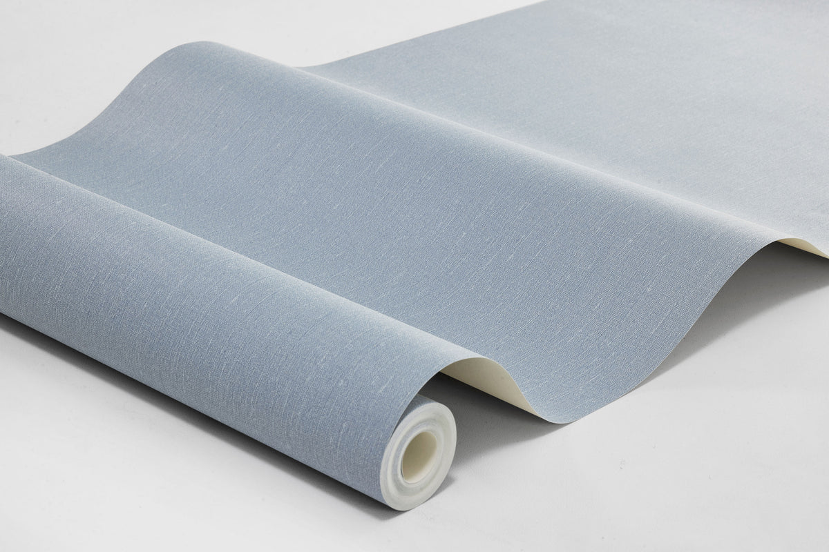  Linen Sky comes in a balanced medium-dark Blue shade that evokes the Scandinavian sky and sea. The wallpaper has a tactile linen texture that gives the color a vibrant depth and a soft, cozy character. 