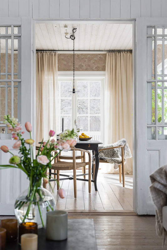 Sonja is a classic floral wallpaper with a modern twist. Light flowers on stems and dots spread across the surface.