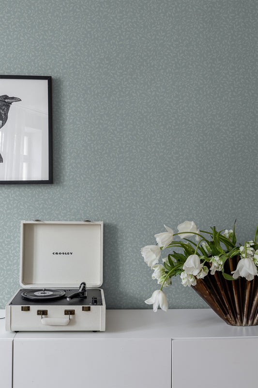 The wallpaper Folke is an elegant climbing foliage reminiscent of blueberry branches.