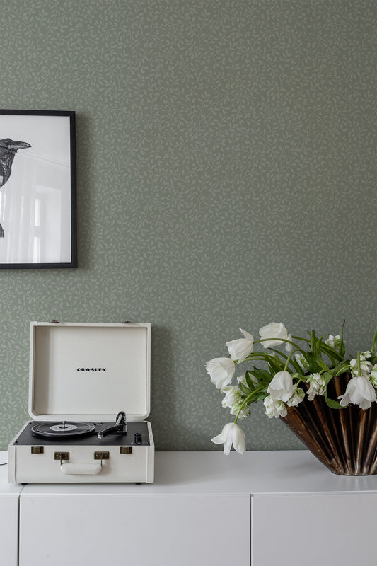 The wallpaper Folke is an elegant climbing foliage reminiscent of blueberry branches.