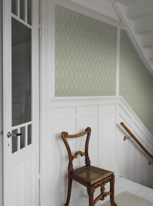 Soothing and tranquil, our Signe wallpaper is set on a linden green background with yellow-green detailing.