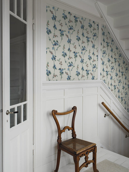 Colored in a palette of misty blue, brown and cool green-blue on a linen background, our Vera wallpaper in collagraph print features a 1920’s vintage pattern from our archives.