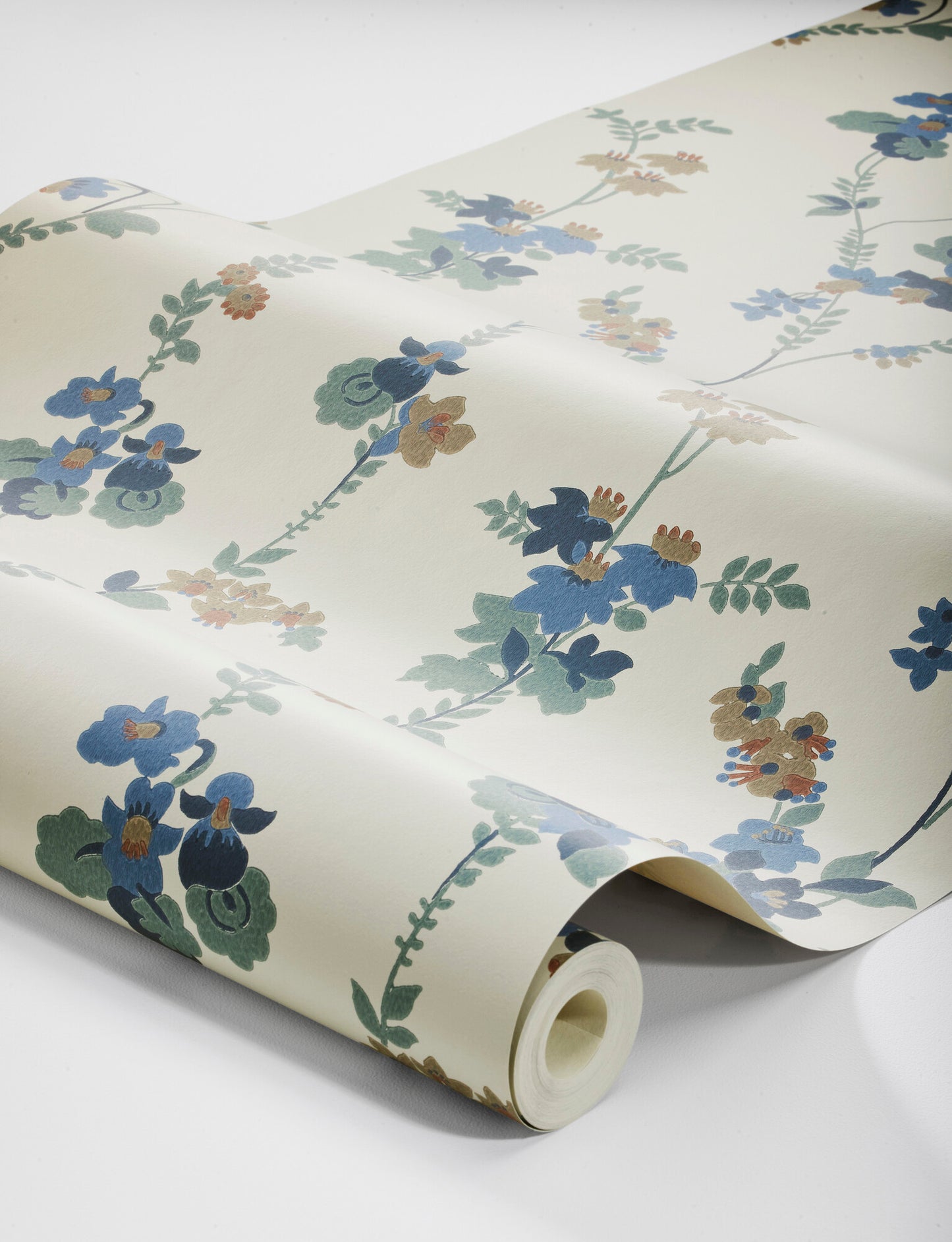 Colored in a palette of misty blue, brown and cool green-blue on a linen background, our Vera wallpaper in collagraph print features a 1920’s vintage pattern from our archives.