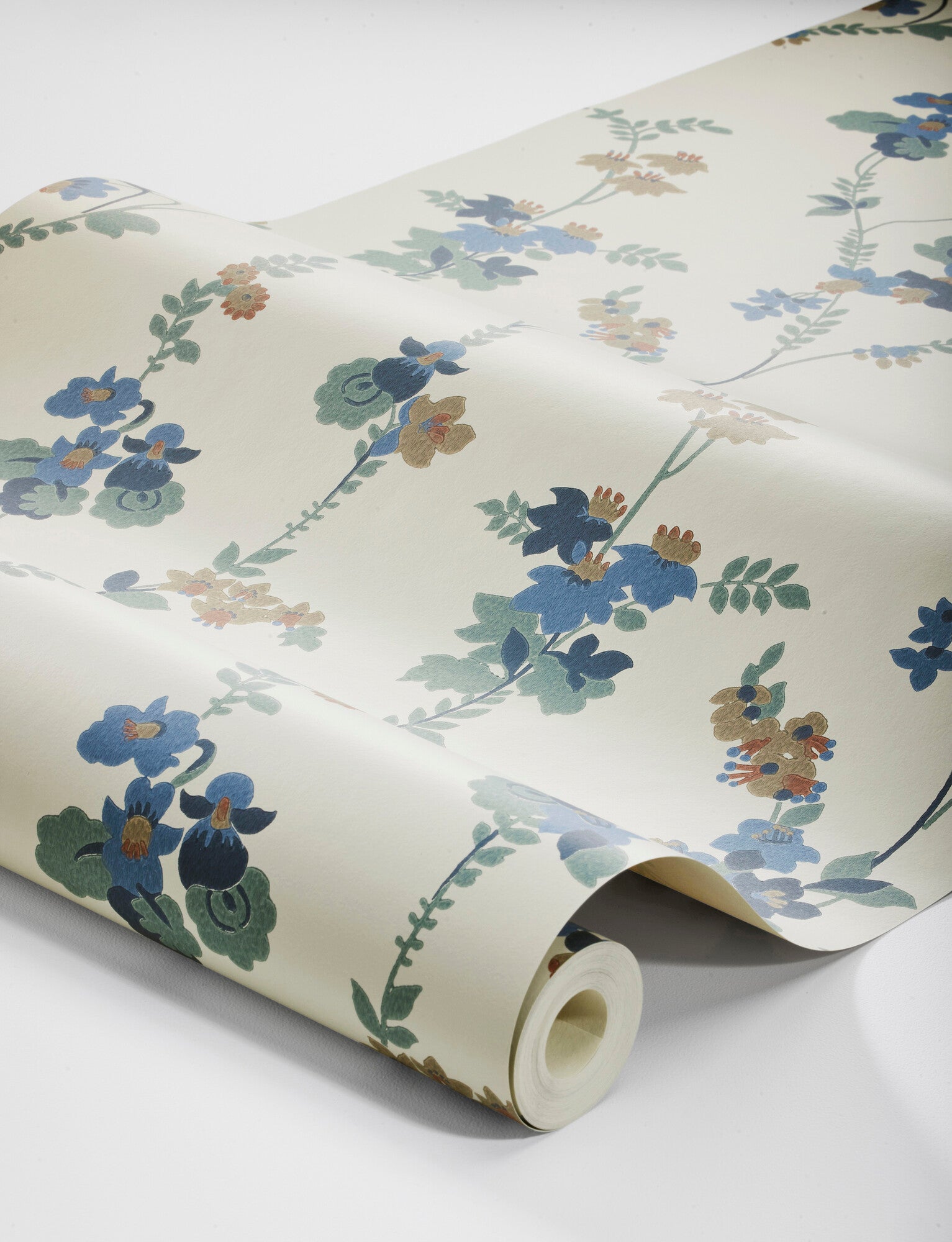 Colored in a palette of misty blue, brown and cool green-blue on a linen background, our Vera wallpaper in collagraph print features a 1920’s vintage pattern from our archives.