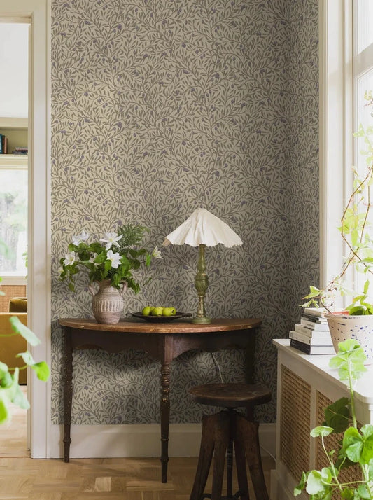 Indulge in the vibrant allure of our Olivträd wallpaper in contemporary tones of green, purple, beige and brown set on a muted, soft yellow-green background.