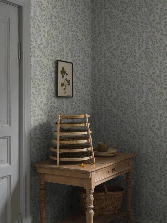 Step into a poetic and vintage oasis with our Blåregn wallpaper in a surface print that gives a beautiful rustic expression to the floral pattern. 