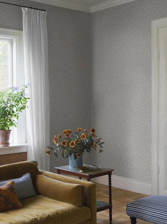 Step into a world of rustic charm with our Myrten wallpaper in a surface print. Colored in a palette of muted light blue, creamy white, and grey beige, it features a dense and decorative hand-painted floral and foliage pattern by Ulrica Hurtig.